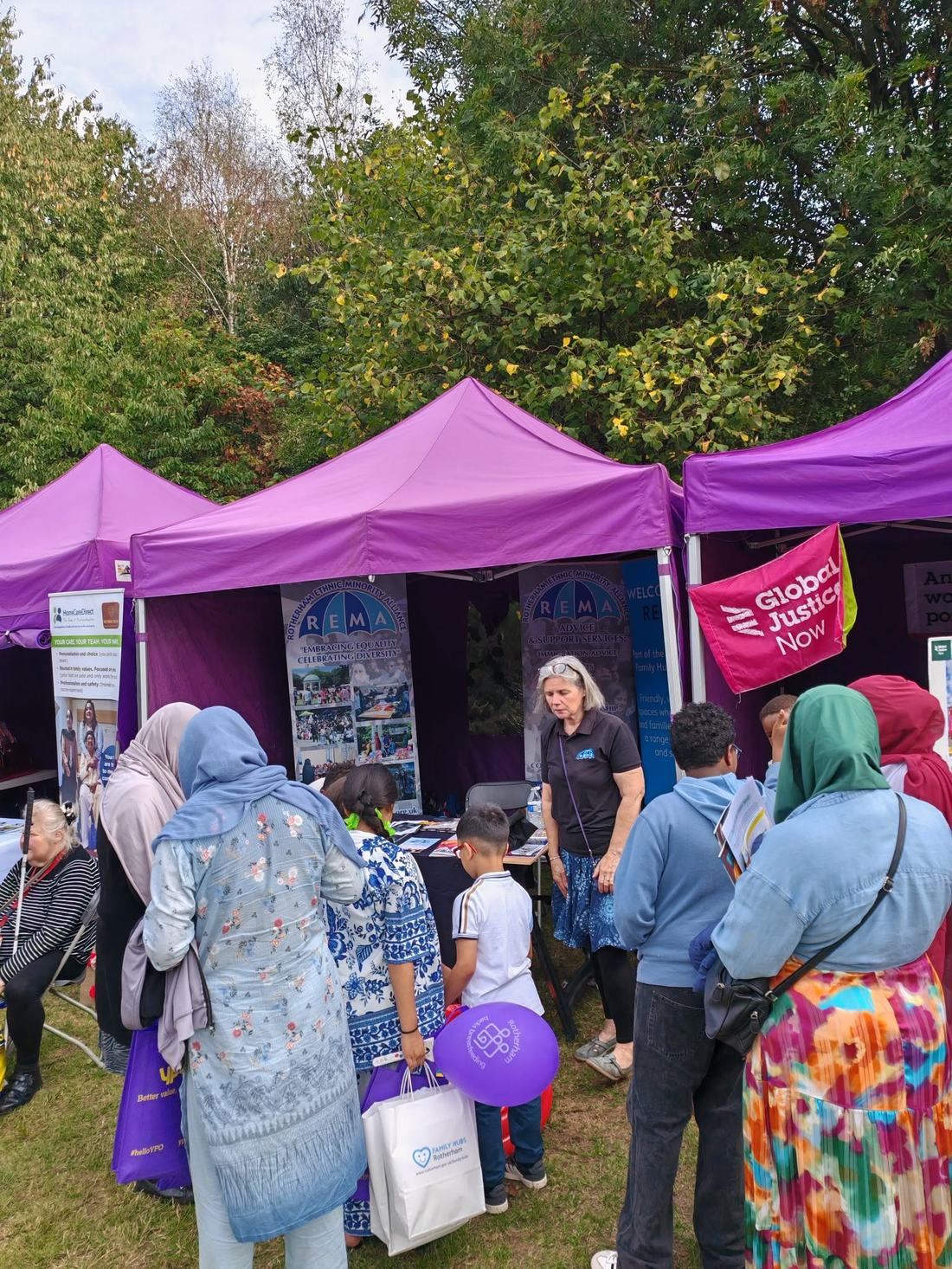 REMA staff and volunteers at a community outreach stall in Rotherham, talking with visitors of different backgrounds